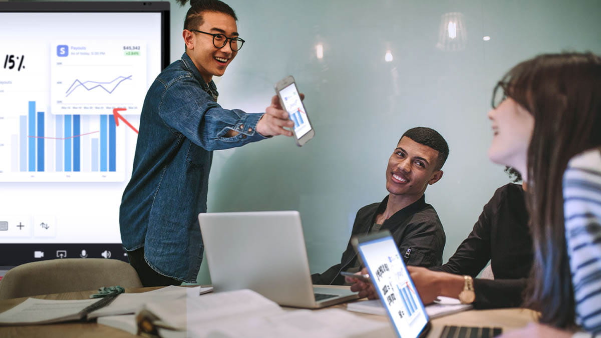 Higher education students using SMART Board to review financial graphs, enhancing their learning experience.