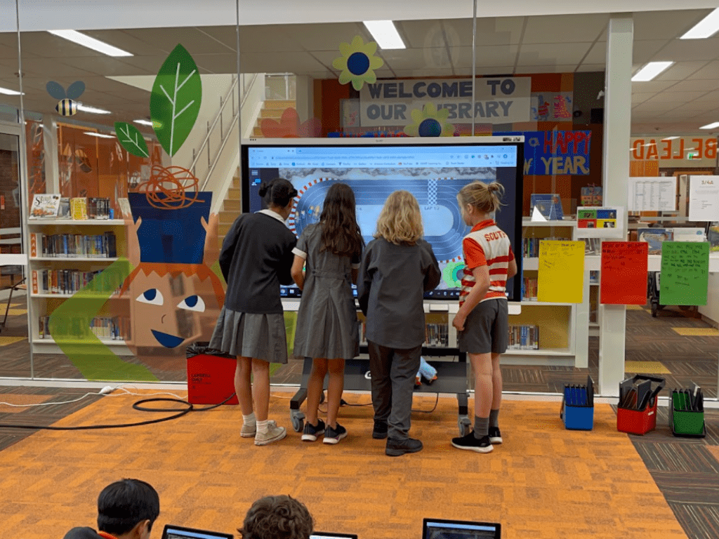 A group of students working collaboratively on an interactive display.