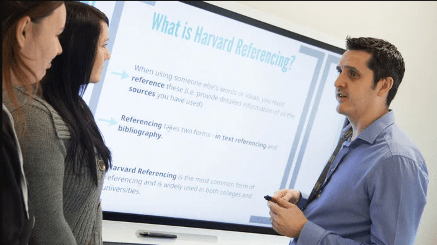 Educator and higher education student connecting in front of an interactive display